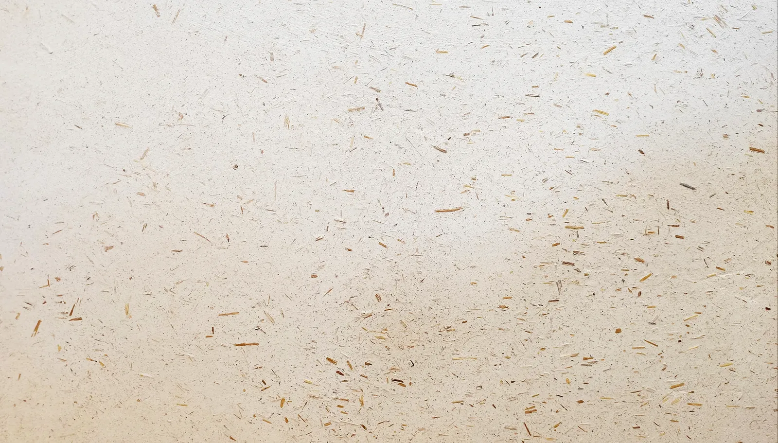 Detail hliněné stěrky se slámou, materiálová textura povrchu