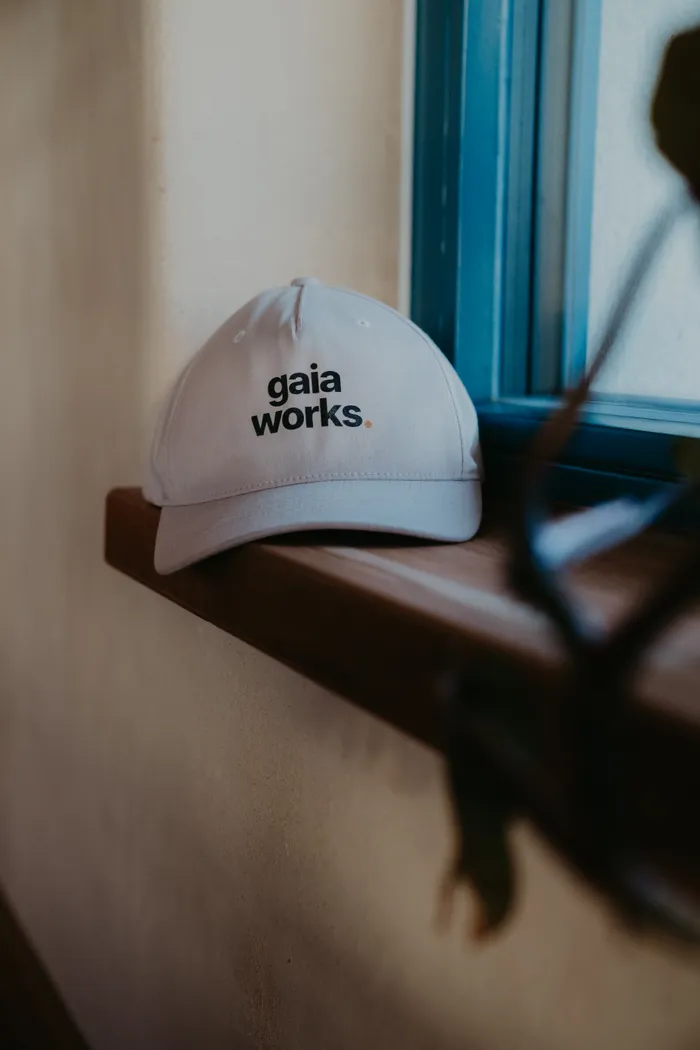 Kšiltovka s nápisem gaia works na dřevěném parapetu